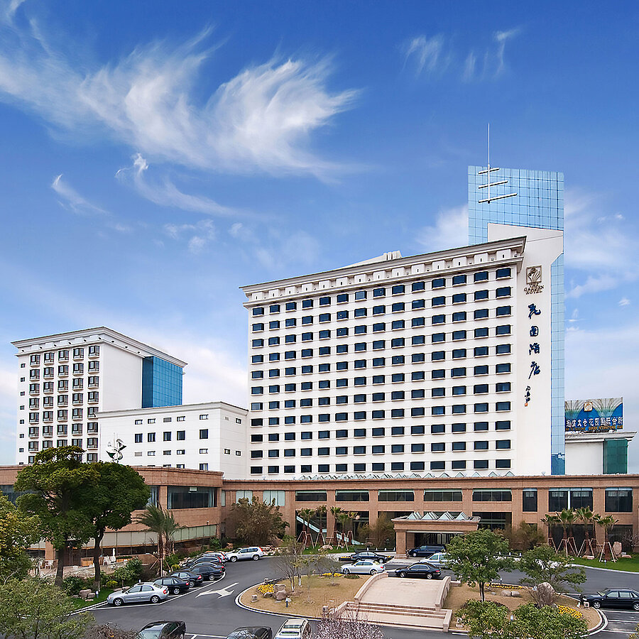 Außenansicht Außenansicht des Hotels mit hoher Fassade, modernem Anbau und umliegender Grünanlage für einen einladenden ersten Eindruck