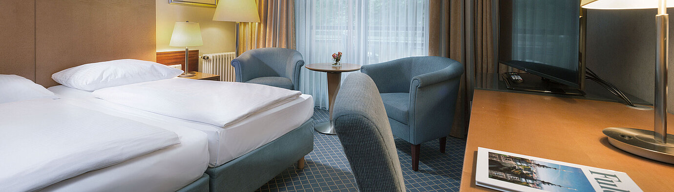 Comfort Zimmer Comfort Doppelzimmer im Maritim Hotel Fulda mit modernen Möbeln, Schreibtisch und gemütlicher Sitzecke.