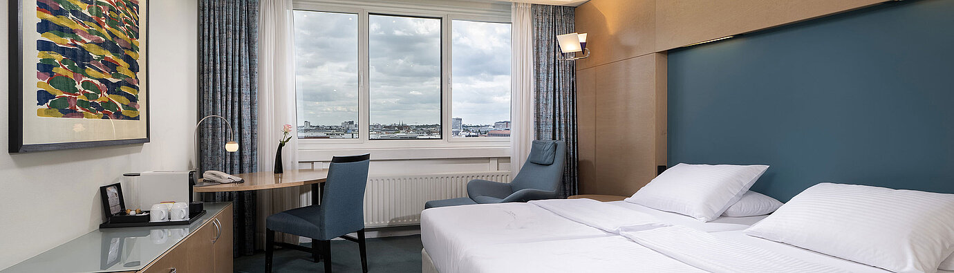 Superior Zimmer mit Doppelbett, Schreibtisch, Sessel und weitem Blick über Berlin im Maritim proArte Hotel