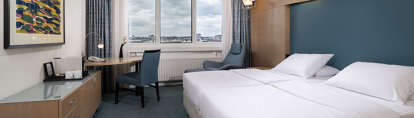Superior Zimmer mit Doppelbett, Schreibtisch, Sessel und weitem Blick über Berlin im Maritim proArte Hotel