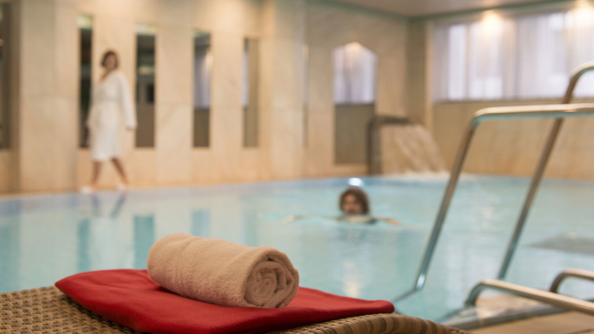 Handtuch am Pool im Wellnessbereich des Maritim Hotel Stuttgart, Gäste genießen das Schwimmen