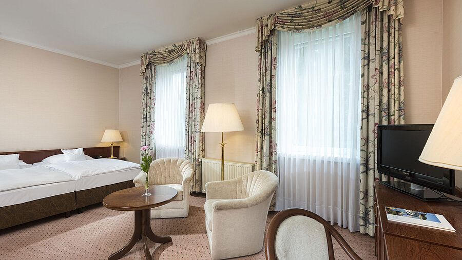 Großes Doppelzimmer mit zwei Fenstern und Sitzgruppe im Maritim Hotel Bad Wildungen
