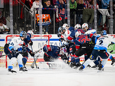 Eishockeyspieler kämpfen hart um den Puck vor dem Tor in einem spannenden DEL-Spiel.