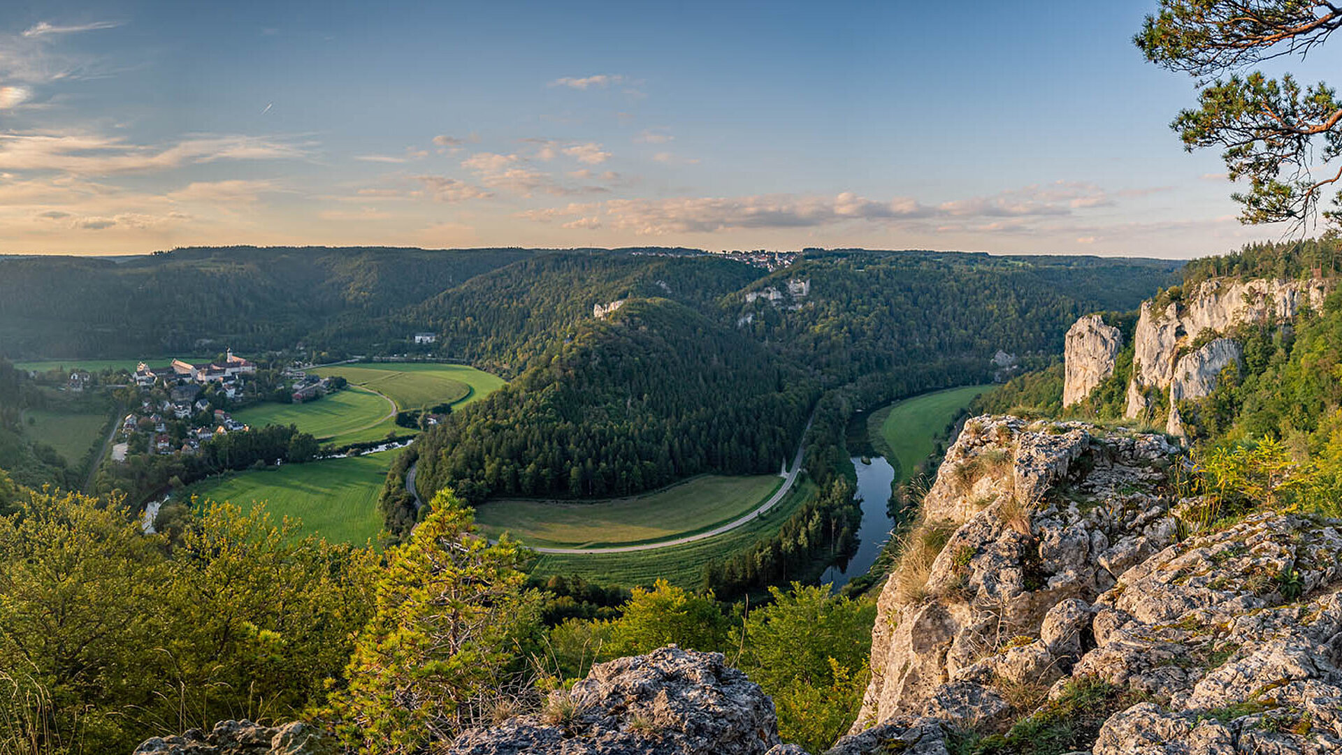 Panorama über das Donautal mit Fluss, grünen Wiesen und steilen Felsen