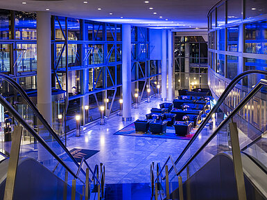 Modern beleuchtete Lobby des Maritim Hotel Frankfurt bei Nacht mit stilvollen Sitzbereichen.