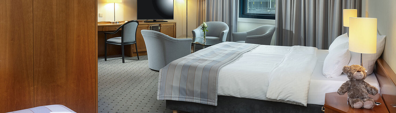Classic Familienzimmer Großzügiges Familienzimmer mit Doppelbett, Sitzecke und Blick auf den Flughafen im Maritim Hotel Hannover.