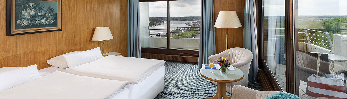 Doppelzimmer mit Panoramafenstern und Blick auf den Hafen von Travemünde im Maritim Hotel