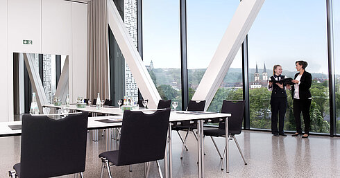 Moderner Tagungsraum im Maritim Hotel Würzburg mit großem Fenster, Ausblick und zwei sprechenden Personen