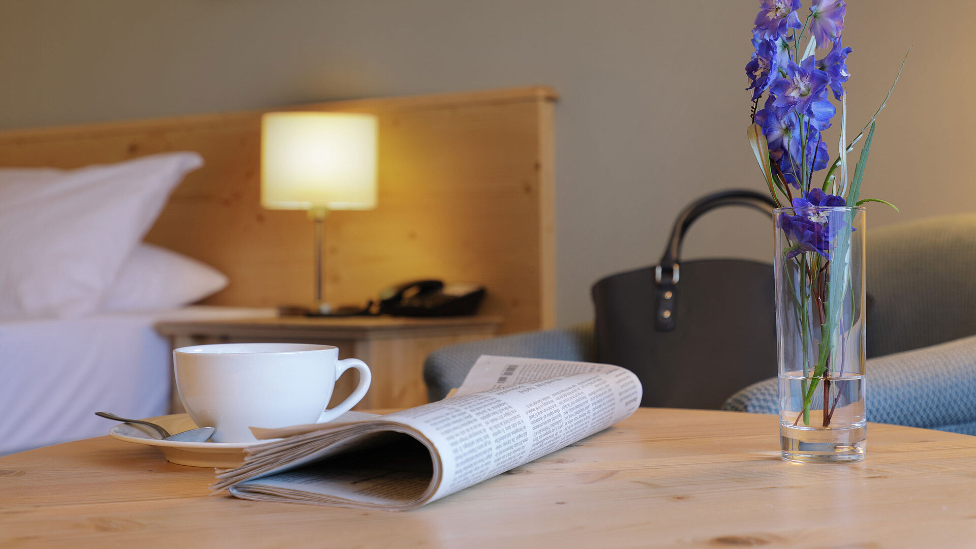 Zimmerdetail Tasse Kaffee, Zeitung und Blume auf Tisch im Zimmer des Maritim Hotel Titisee