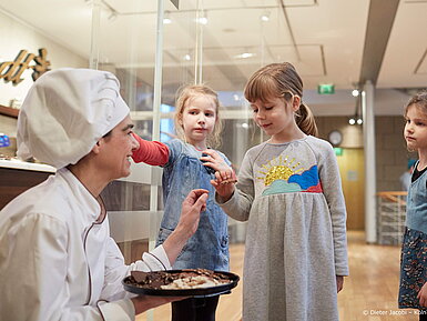 Kinder probieren Süßigkeiten in Schokoladenmuseum