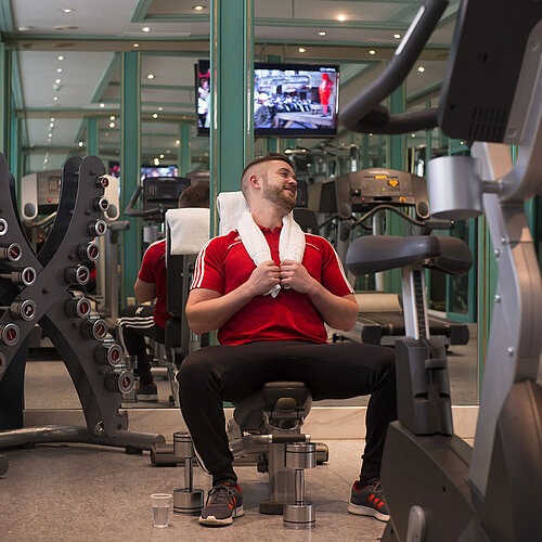 Gast im Fitnessraum des Maritim Hotel Stuttgart beim Training mit Hanteln und Geräten