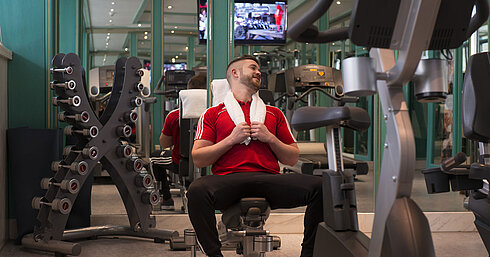 Gast im Fitnessraum des Maritim Hotel Stuttgart beim Training mit Hanteln und Geräten