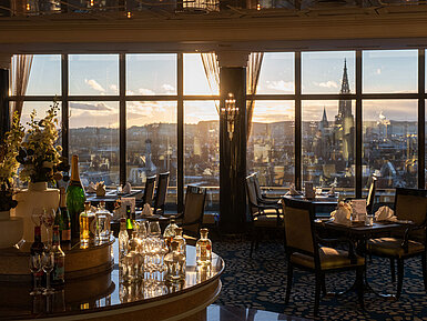 "Das Ulmer" Restaurant Restaurant im Maritim Hotel Ulm mit Gläsern am Rondell, großen Fenstern und Blick über Ulm bei Sonnenuntergang