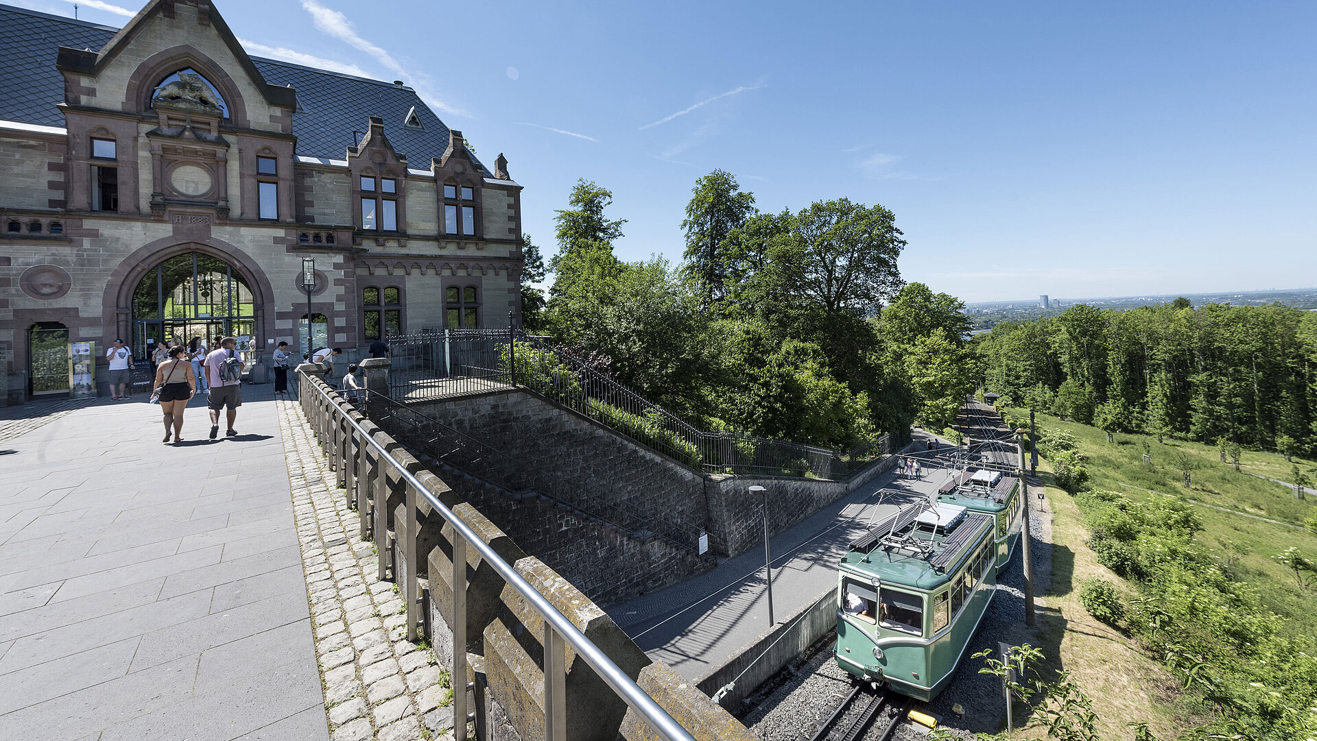 Schloss Drachenburg Die Drachenfelsbahn am historischen Bahnhof mit Besuchern, die sich auf den Aufstieg vorbereiten.