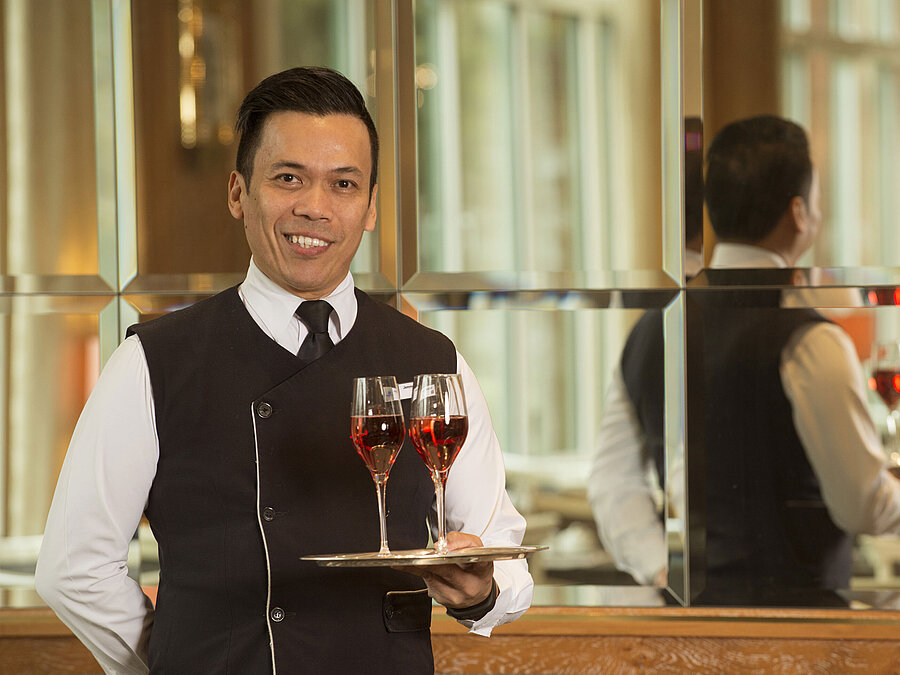 Kellner mit zwei Gläsern Roséwein auf Silbertablett im Maritim Hotel Stuttgart, freundlich und professionell