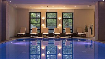 Poolbereich des Maritim Hotel Bonn mit stilvollen Liegen und beruhigender Beleuchtung für ultimative Entspannung.