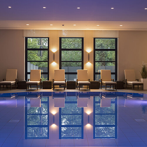 Poolbereich des Maritim Hotel Bonn mit stilvollen Liegen und beruhigender Beleuchtung für ultimative Entspannung.
