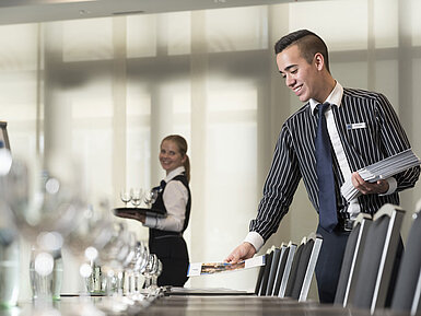 Maritim Tagungsservice Freundliches Serviceteam im Maritim Hotel Bad Homburg bereitet Tagungsraum vor.