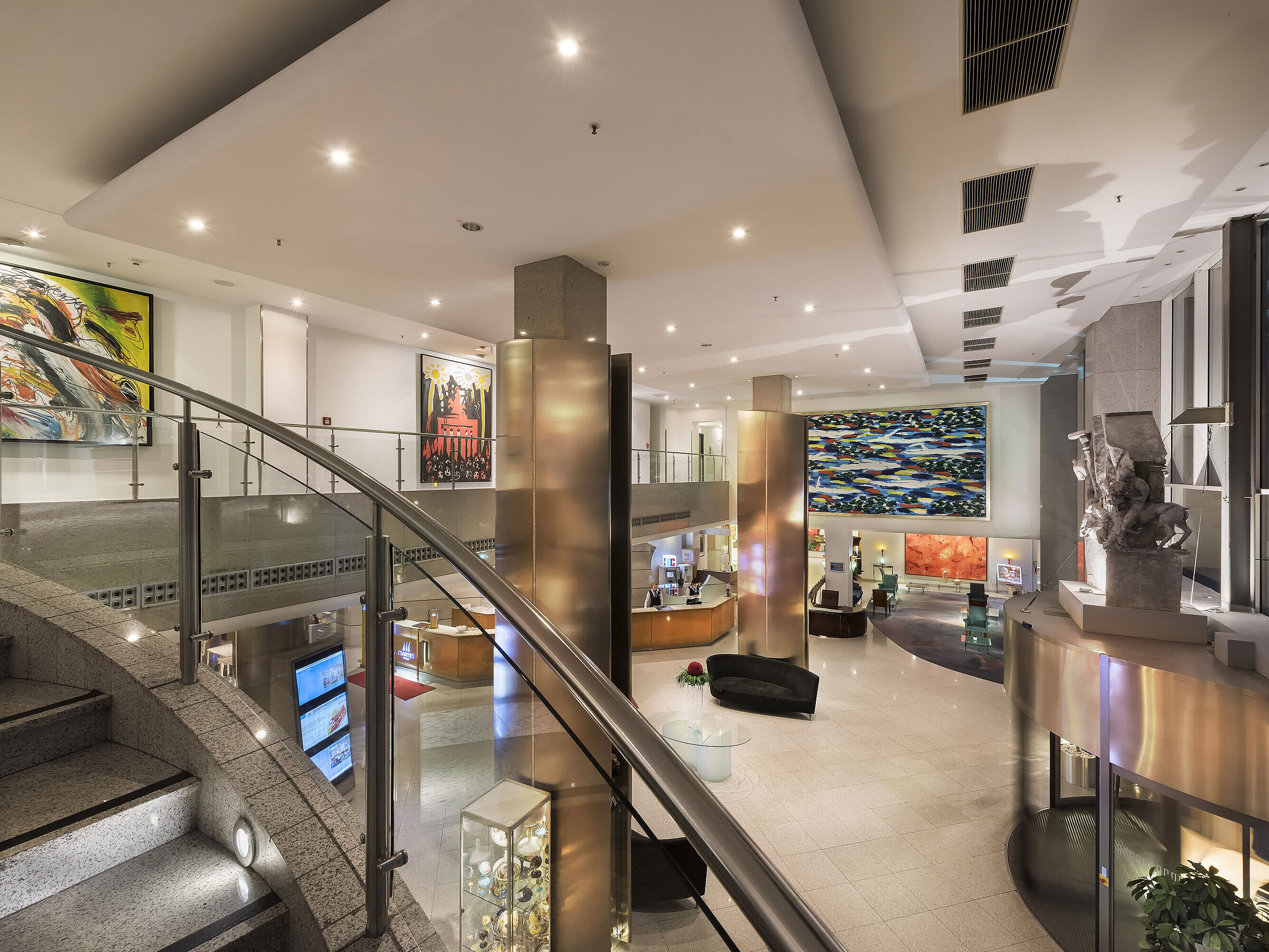 Großzügige, moderne Lobby des Maritim proArte Hotels mit Kunstwerken, geschwungenen Treppen und elegantem Interieur.
