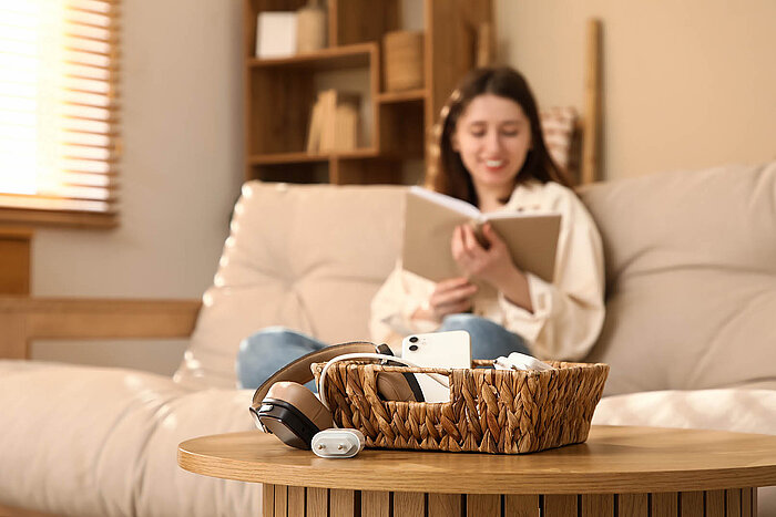 Junge Frau entspannt auf dem Sofa mit Buch – gemütlicher Moment zu Hause mit Fokus auf Ruhe und Entspannung