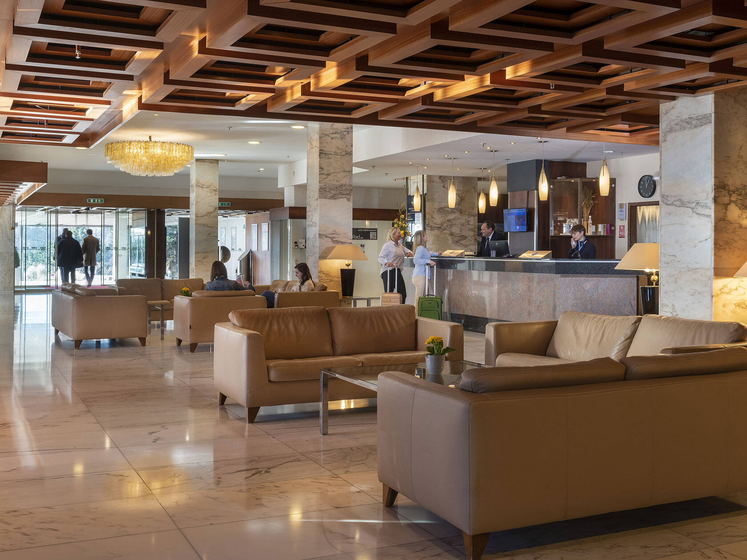 Großzügige Lobby mit Marmorboden, Ledersofas und Empfangsbereich im Maritim Hotel Travemünde
