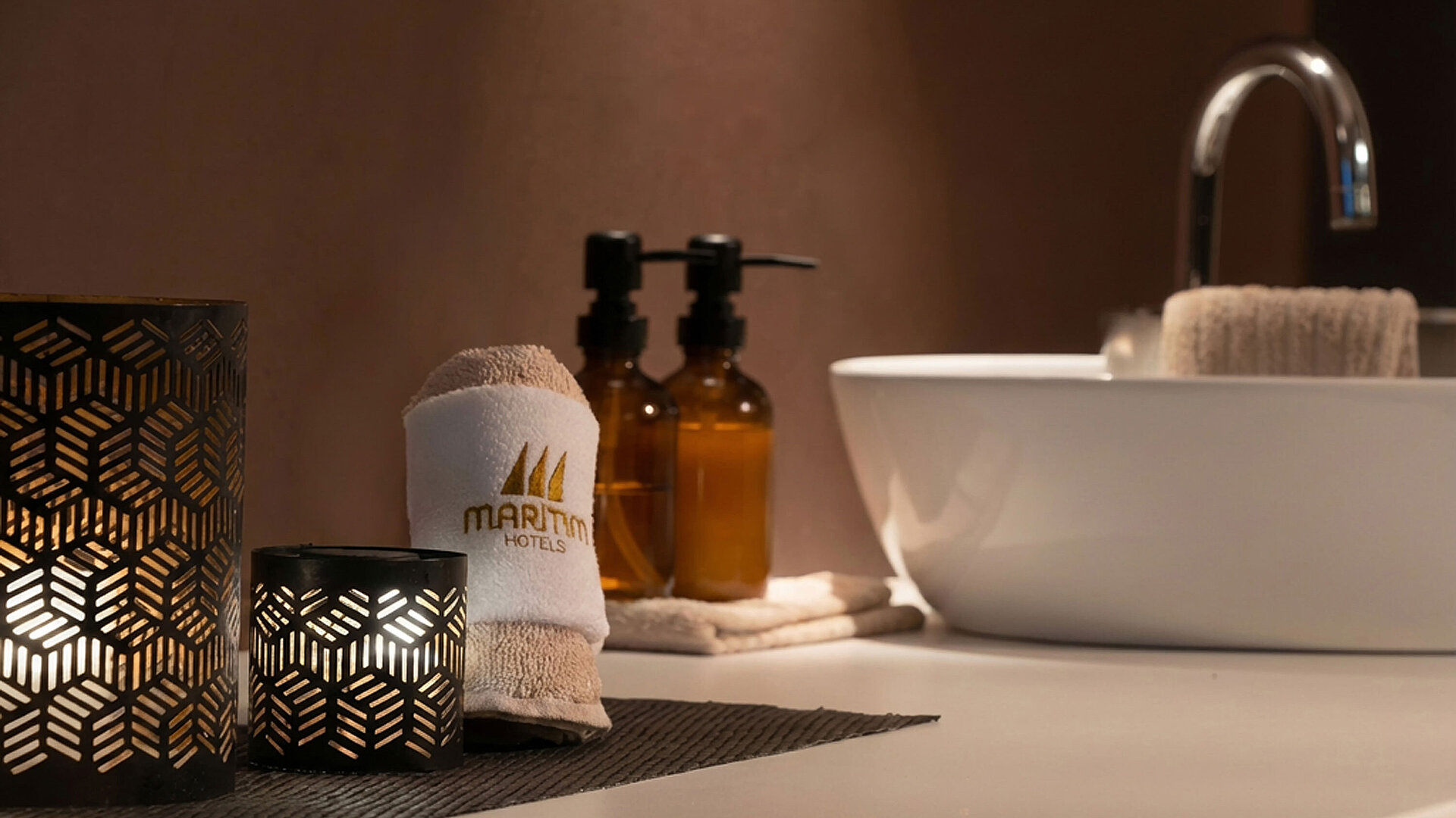 Stilvolles Badezimmer mit Maritim Handtuch, Pflegeprodukten und Waschbecken.