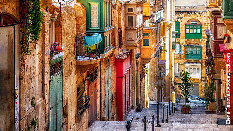 Bunte Häuser und enge Gasse in Valletta auf Malta mit traditionellen Holzbalkonen