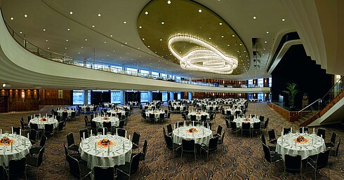 Eleganter Veranstaltungssaal im Maritim Hotel Düsseldorf, festlich gedeckt mit runden Tischen und beeindruckender Beleuchtung.