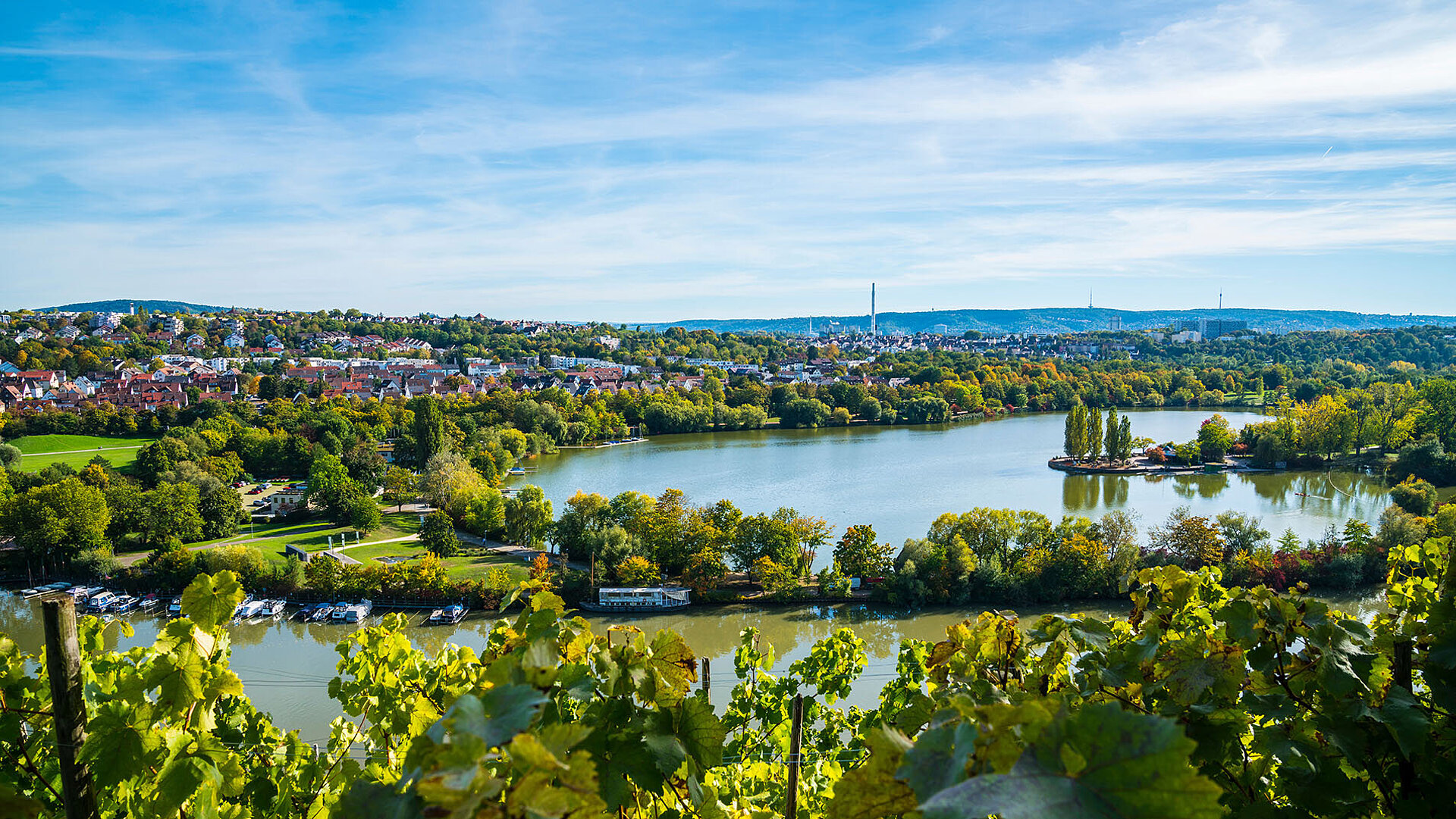 Panoramablick über Stuttgart mit grüner Landschaft, dem Max-Eyth-See und dem Neckar.