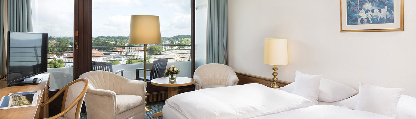 Helles Doppelzimmer im Maritim Hotel Travemünde mit Balkon und Blick über Dächer und Wasser