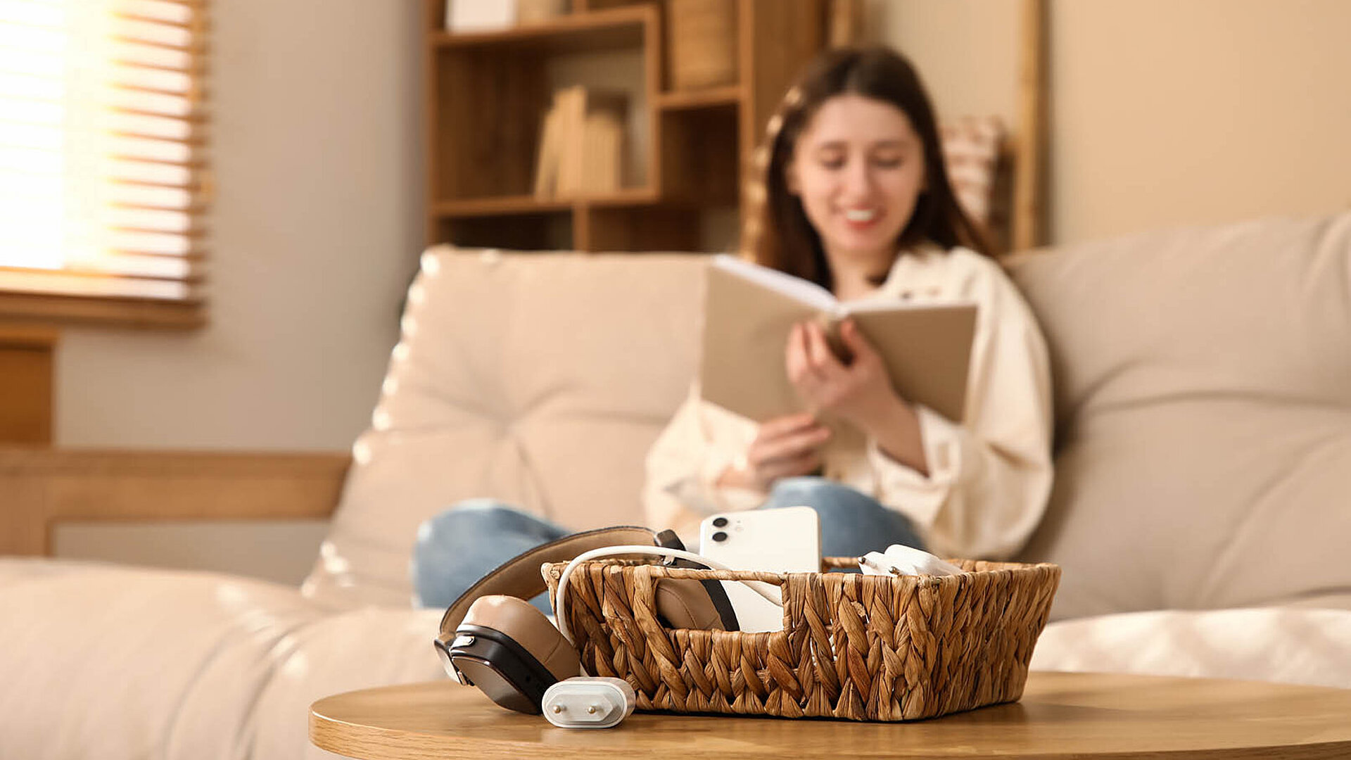 © Pixel-Shot AdobeStock.com.jpg Junge Frau entspannt auf dem Sofa mit Buch – gemütlicher Moment zu Hause mit Fokus auf Ruhe und Entspannung
