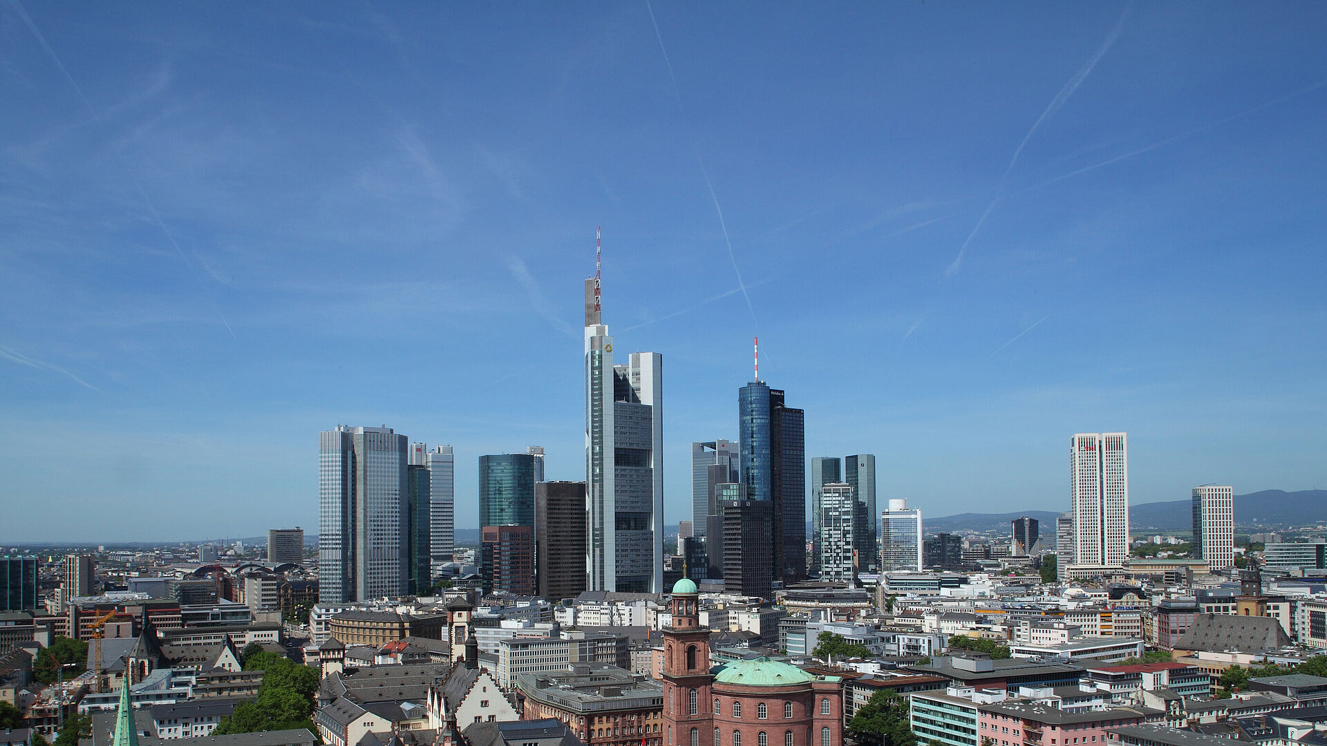 Blick auf die Skyline von Frankfurt mit dem Römer und der Paulskirche im Vordergrund bei klarem Himmel.