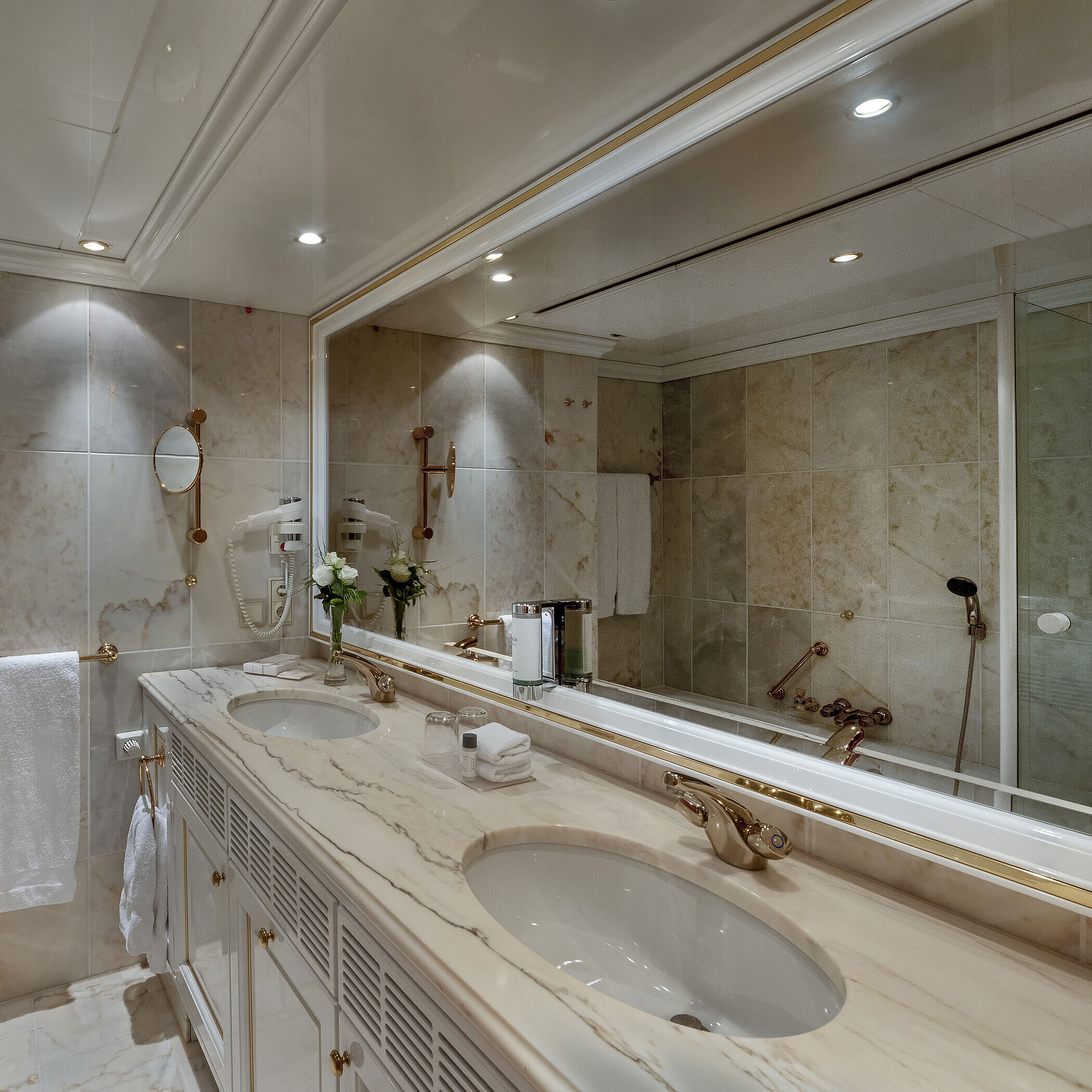 Bad Marmorbadezimmer im Maritim Airport Hotel Hannover mit Doppelwaschtisch, Spiegel und Badewanne.