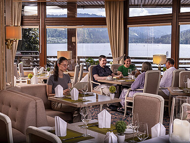 Gäste genießen das Essen im stilvollen Restaurant mit Panoramablick auf den Titisee