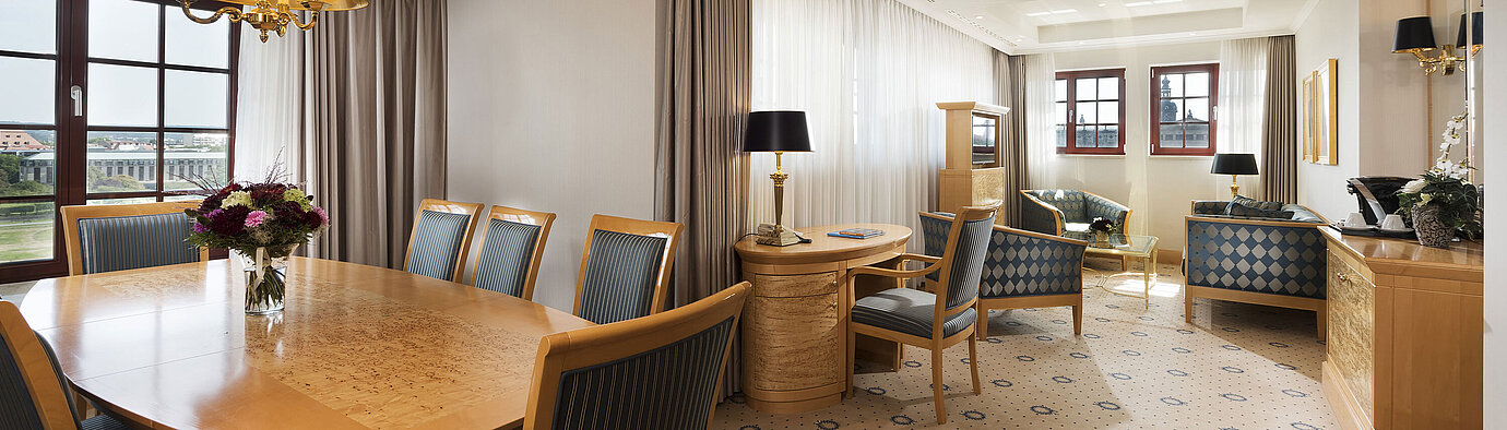Geräumige Executive Suite im Maritim Hotel Dresden mit elegantem Esstisch, komfortabler Sitzecke und Blick auf die Stadt.