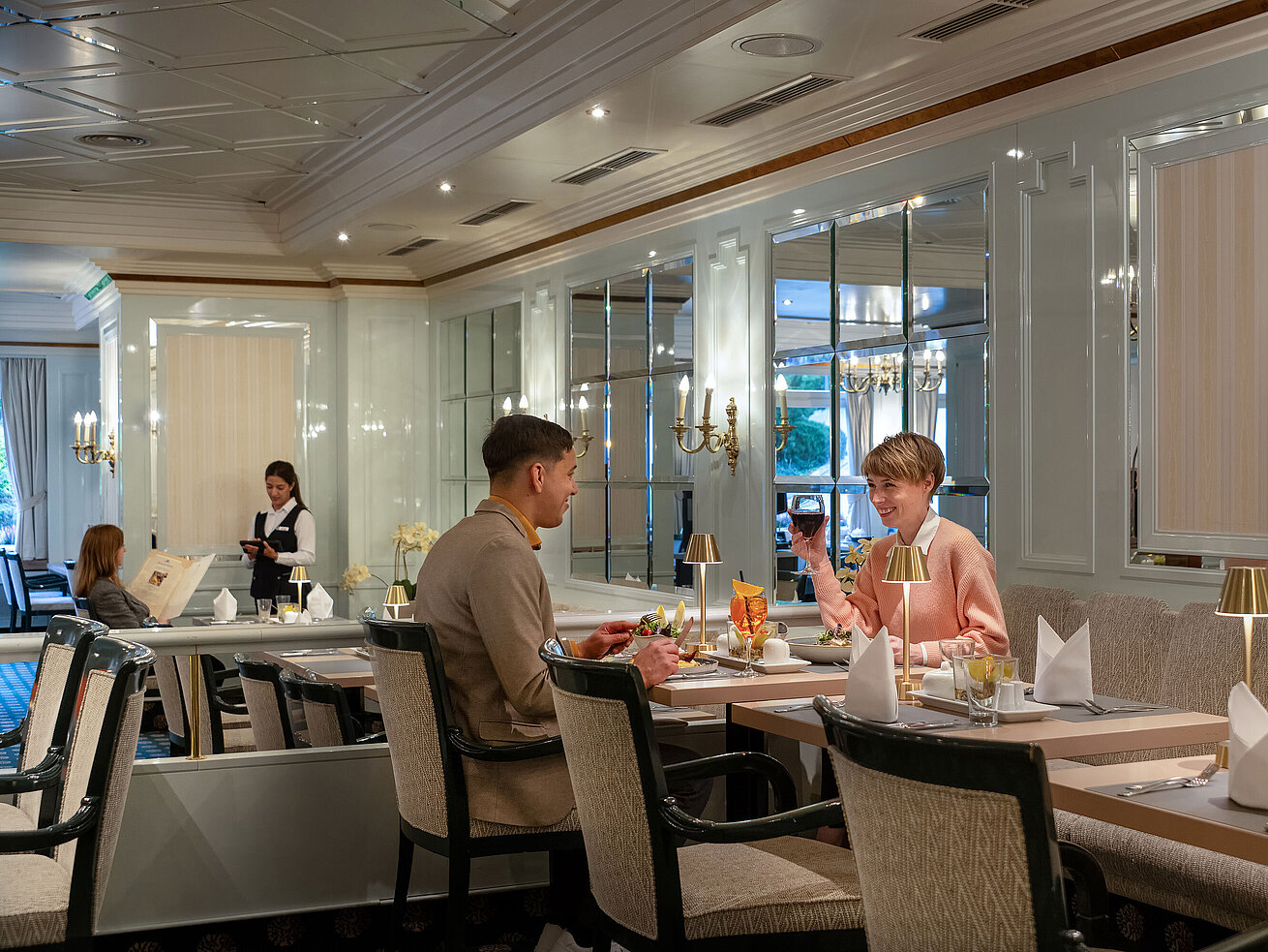 Restaurant Maritim mit Gästen beim Abendessen, elegant gedeckten Tischen und hellem, stilvollem Ambiente.
