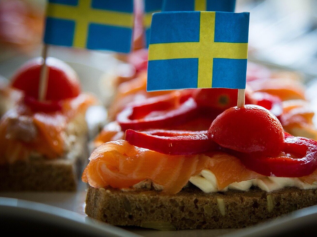 Skandinavischer Snack Skandinavischer Snack mit Lachs, Paprika und Tomaten, dekoriert mit kleinen Schwedenflaggen.