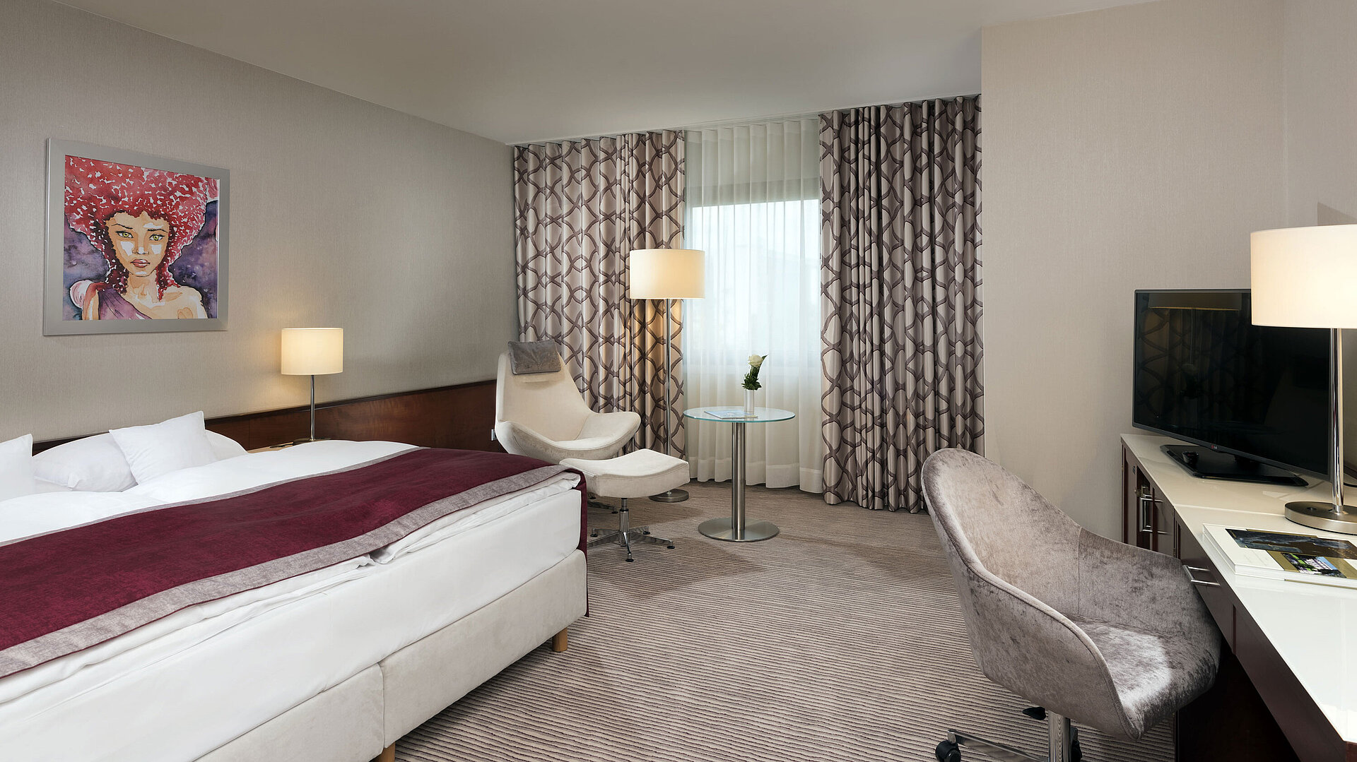 Comfort Zimmer im Maritim Hotel Bonn mit gemütlichem Bett, Sesseln, Schreibtisch und modernen Vorhängen.