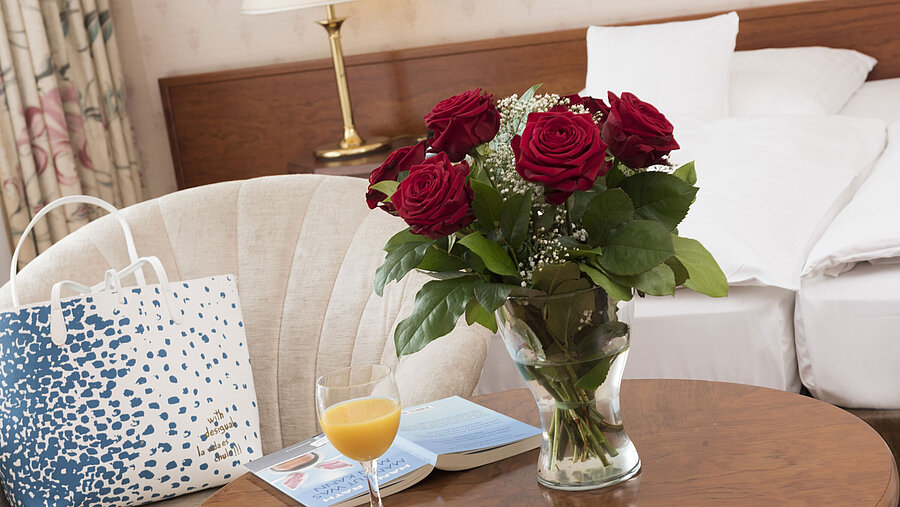 Frische Rosen, Saft und Lektüre auf dem Tisch im Doppelzimmer des Maritim Hotel Bad Wildungen