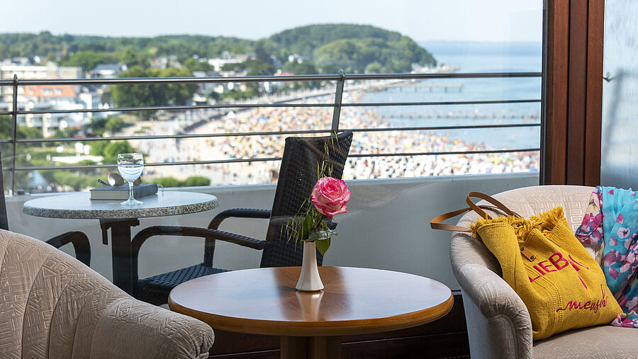 Aussicht vom Zimmerbalkon im Maritim Hotel Travemünde auf den Strand mit Rose und Getränk