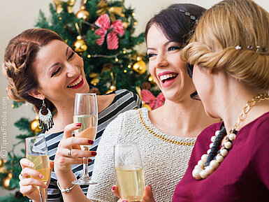 Drei junge Frauen stoßen mit Champagner an