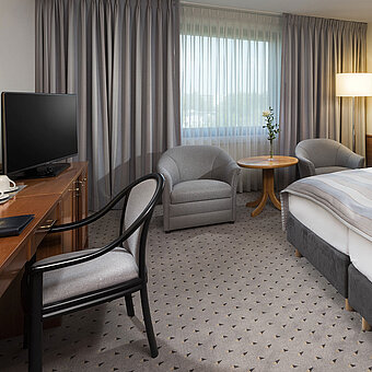 Modernes Classic Doppelzimmer mit gemütlichem Doppelbett, Sitzbereich und Schreibtisch im Maritim Hotel Hannover.