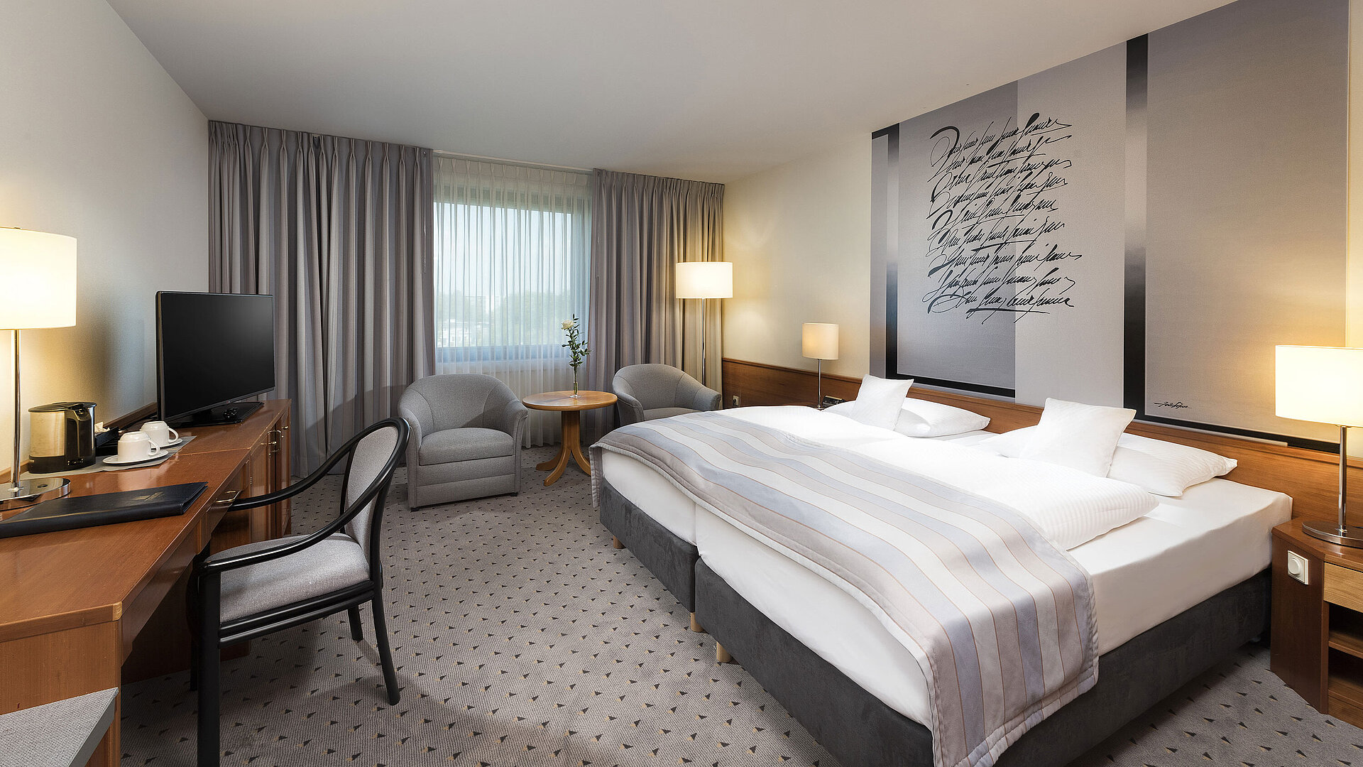 Modernes Classic Doppelzimmer mit gemütlichem Doppelbett, Sitzbereich und Schreibtisch im Maritim Hotel Hannover.