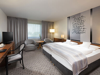 Modernes Classic Doppelzimmer mit gemütlichem Doppelbett, Sitzbereich und Schreibtisch im Maritim Hotel Hannover.