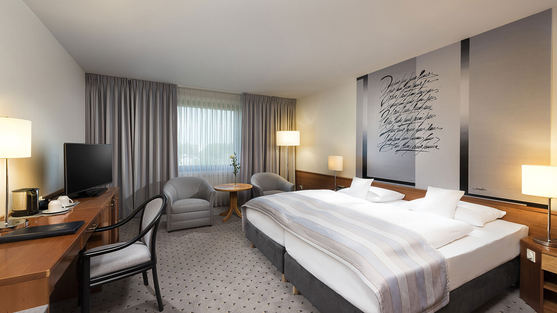 Modernes Classic Doppelzimmer mit gemütlichem Doppelbett, Sitzbereich und Schreibtisch im Maritim Hotel Hannover.