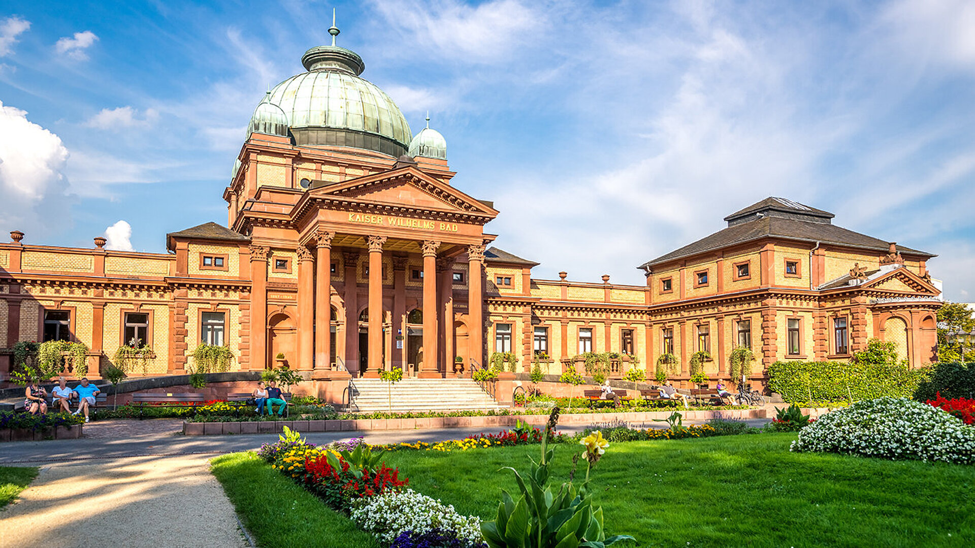 Historisches Kurhaus Bad Homburg mit prachtvoller Kuppel, gepflegten Gartenanlagen und Blumenbeeten.