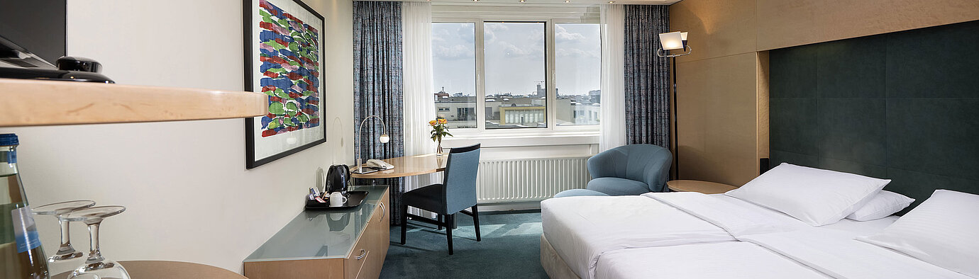 Comfort Zimmer mit Doppelbett, Schreibtisch und gemütlicher Sitzecke im Maritim proArte Hotel Berlin