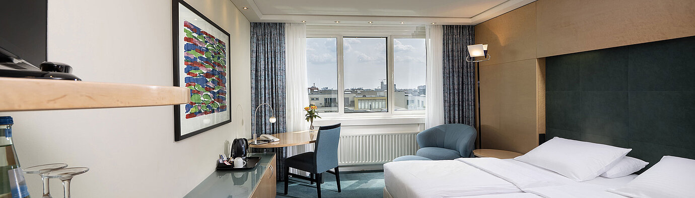 Comfort Zimmer mit Doppelbett, Schreibtisch und gemütlicher Sitzecke im Maritim proArte Hotel Berlin