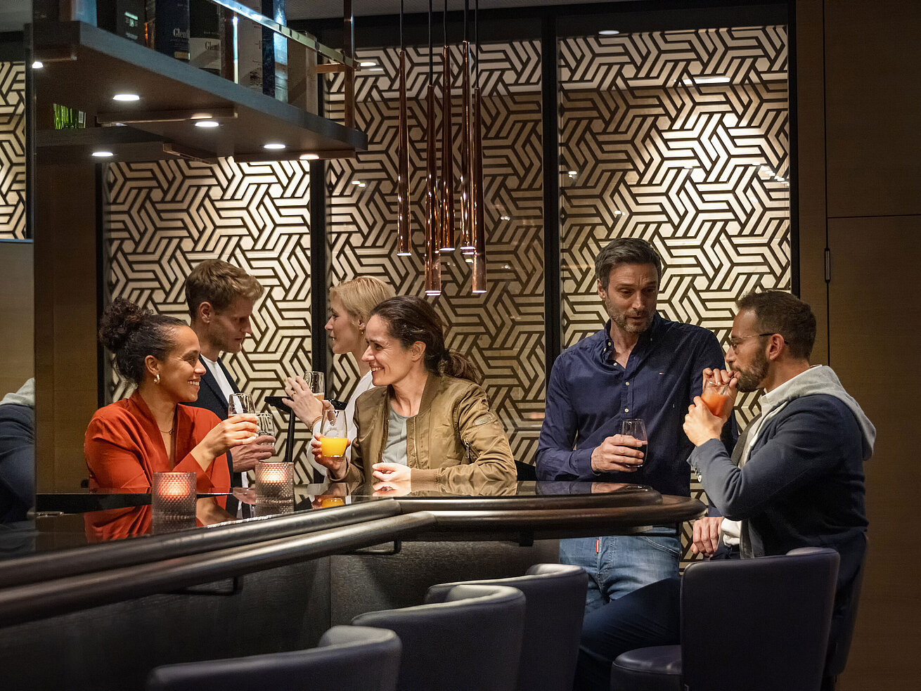 Gäste genießen Drinks und gesellige Gespräche in der stilvollen Bar des Maritim Hotel Ingolstadt.
