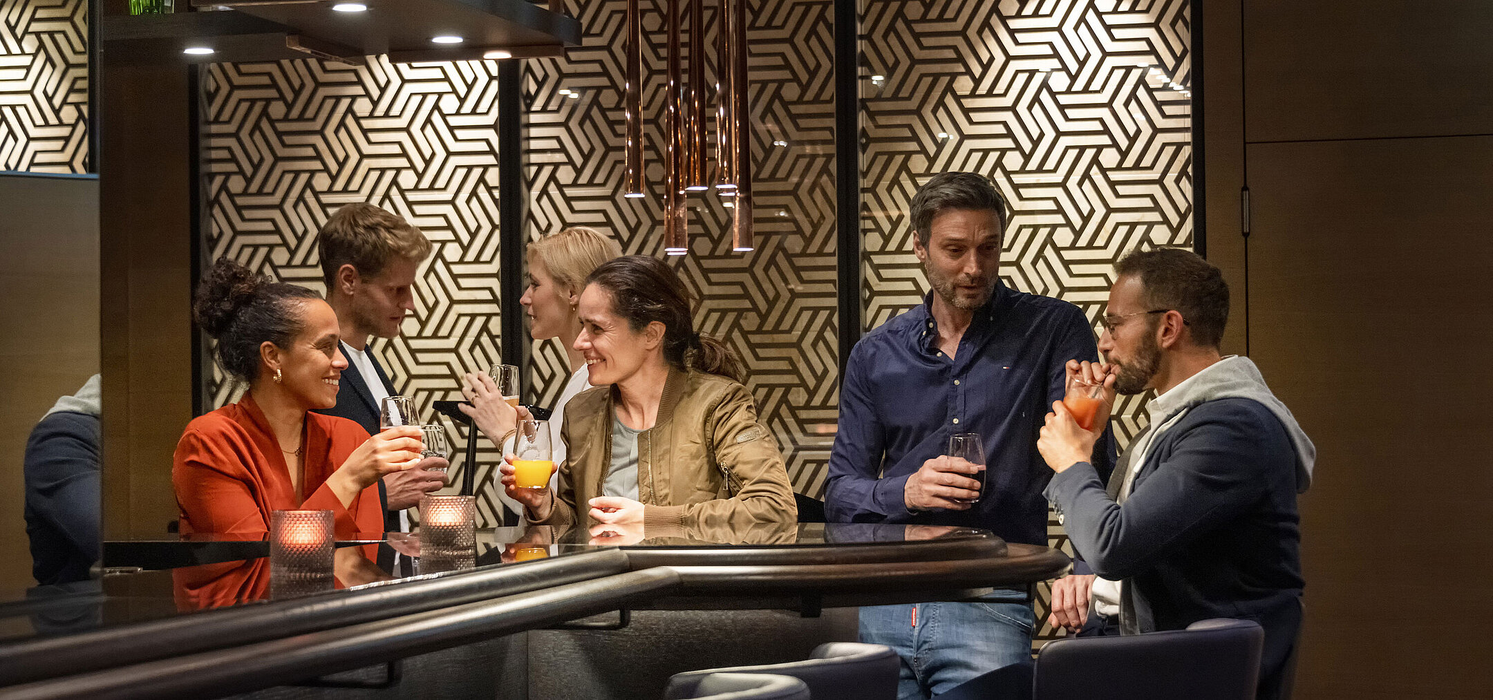 Gäste genießen Drinks und gesellige Gespräche in der stilvollen Bar des Maritim Hotel Ingolstadt.
